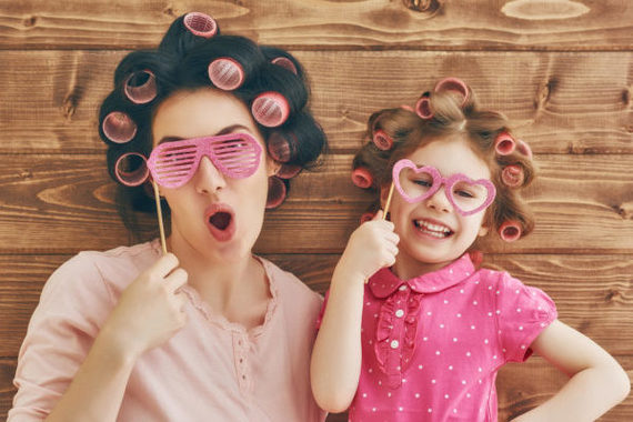 Funny family! Mother and her child daughter girl with a paper ac