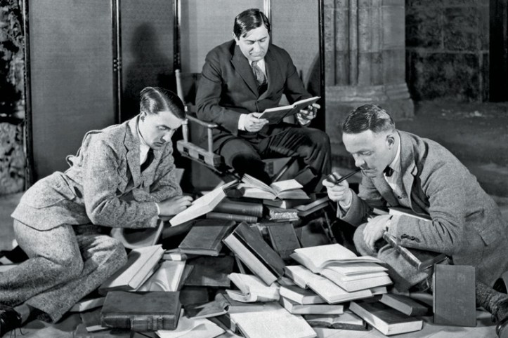 group-of-men-reading-pile-of-books
